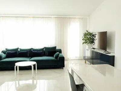 a living room with a green couch and a table at Golden Gate 21 in Ruma