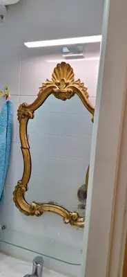 a gold mirror on a wall in a bathroom at Dream apartment Beograd in Belgrade