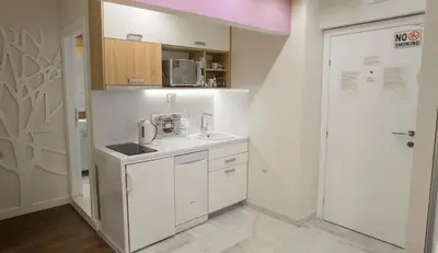 a white kitchen with a sink and a microwave at Apartments Tom&Jerry in Belgrade