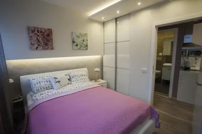a bedroom with a bed with a purple blanket at Apartments Tom&Jerry in Belgrade