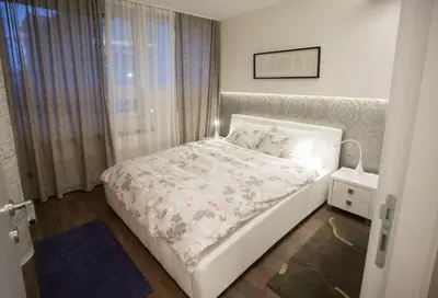 a bedroom with a white bed and a window at Apartments Tom&Jerry in Belgrade