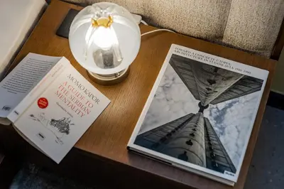 a table with a book and a lamp on it at Chic NEW IvoLola Studio YU modern design gem in Belgrade