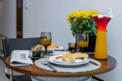 a table with two plates of food and glasses of wine at Chic NEW IvoLola Studio YU modern design gem in Belgrade