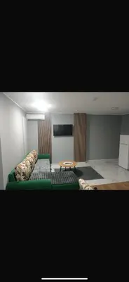 a room with a green bed and a table at melvina 3 in Pančevo