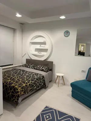 a bedroom with a bed and a round mirror at Modern studio in center of Belgrade in Belgrade