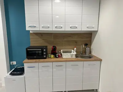 a kitchen with white cabinets and a sink and a microwave at Modern studio in center of Belgrade in Belgrade
