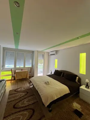 a bedroom with a large bed and a table at Pariske komune in Belgrade