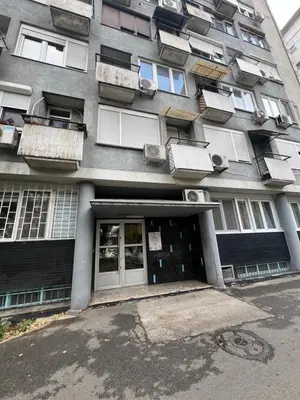 a tall building with windows and a door and a building at Pariske komune in Belgrade