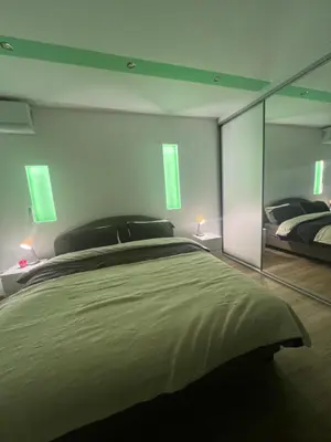 a bedroom with two beds and a large glass wall at Pariske komune in Belgrade