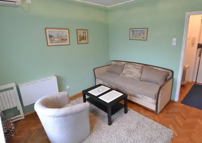 a living room with a couch and a chair and a table at LC Cozy Studio in Belgrade