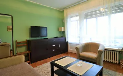 a living room with a couch and a tv at LC Cozy Studio in Belgrade