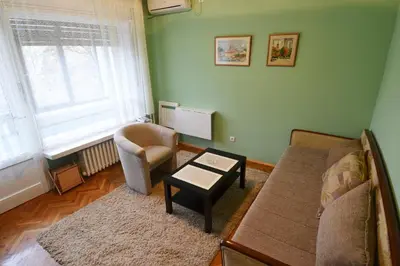 a living room with a couch and a chair at LC Cozy Studio in Belgrade
