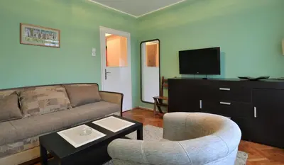 a living room with a couch and a tv at LC Cozy Studio in Belgrade