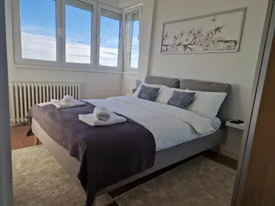 a bedroom with a bed with two towels on it at Royal apartment Novi Mercator in Belgrade