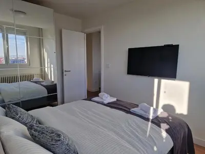 a hotel room with two beds and a flat screen tv at Royal apartment Novi Mercator in Belgrade