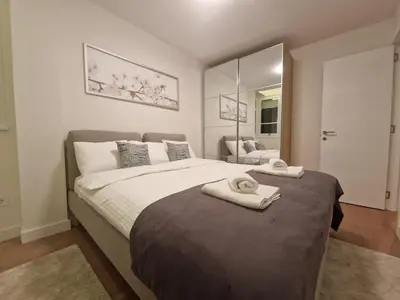 a bedroom with a large bed with two towels on it at Royal apartment Novi Mercator in Belgrade