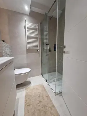 a bathroom with a glass shower and a toilet at Royal apartment Novi Mercator in Belgrade