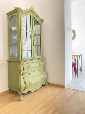 a green cabinet in a room with a table at City center salon-style apartment free parking in Belgrade