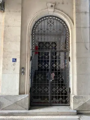 a metal gate on a building with a door at City center salon-style apartment free parking in Belgrade