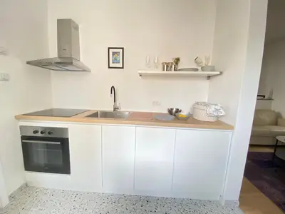 a kitchen with white cabinets and a sink at City center salon-style apartment free parking in Belgrade