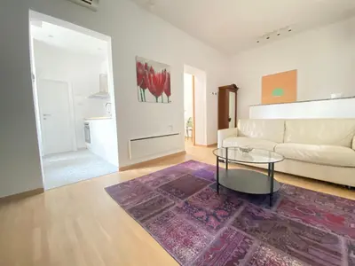 a living room with a white couch and a glass table at City center salon-style apartment free parking in Belgrade