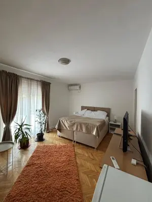 a bedroom with a bed and a flat screen tv at Apartmani IDILA in Smederevo