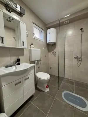 a bathroom with a toilet and a sink and a shower at Apartmani IDILA in Smederevo