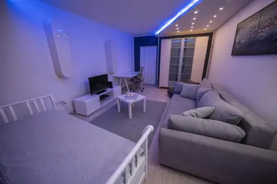 a living room with a couch and a bed at Dove's Nook - A Stylish City Center Retreat in Belgrade