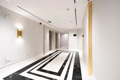 a hallway with a black and white patterned floor at New Belgrade Premium Hotel in Belgrade