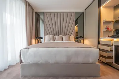 a bedroom with a large bed with a large headboard at New Belgrade Premium Hotel in Belgrade