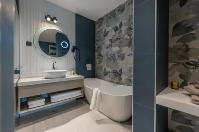 a bathroom with a tub and a sink and a mirror at New Belgrade Premium Hotel in Belgrade