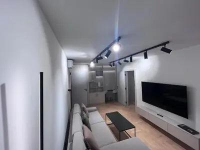 a living room with a couch and a flat screen tv at Urban Central Oasis in Belgrade