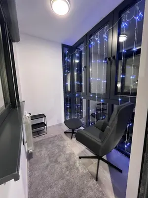 a room with a chair and a window with lights at Urban Central Oasis in Belgrade