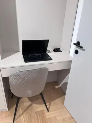 a laptop computer sitting on a white desk with a chair at Urban Central Oasis in Belgrade