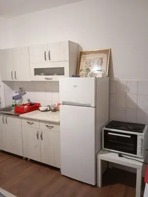 a kitchen with white cabinets and a white refrigerator at Natali apartment in Belgrade