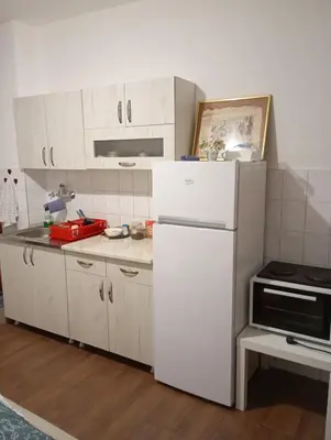 a kitchen with white cabinets and a white refrigerator at Natali apartment in Belgrade