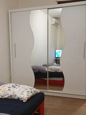 a bedroom with a mirror and a bed in a room at Natali apartment in Belgrade