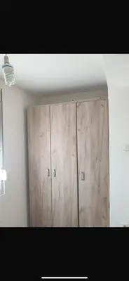 a large wooden cabinet in a room with a ceiling at Apartman- Ledine in Ledine