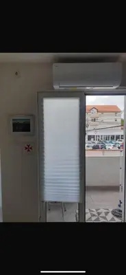 a window with a white blind in a room at Apartman- Ledine in Ledine