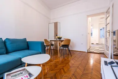 a living room with a blue couch and a table at Black & White Delight in Belgrade