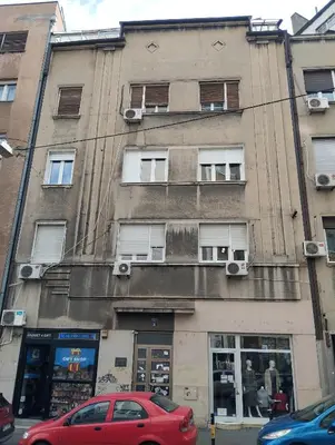a red car parked in front of a building at Black & White Delight in Belgrade