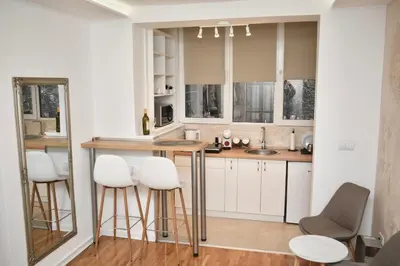 a kitchen with white cabinets and a bar with stools at Studio Ramonda - City Center Dorcol - with Free Parking in Belgrade