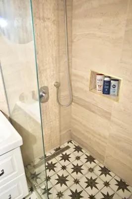 a bathroom with a shower with a tile floor at Studio Ramonda - City Center Dorcol - with Free Parking in Belgrade