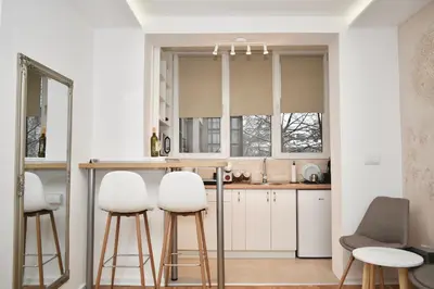 a kitchen with white cabinets and bar stools at Studio Ramonda - City Center Dorcol - with Free Parking in Belgrade