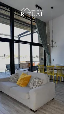 a white couch with yellow pillows in a living room at Ritual splav in Belgrade
