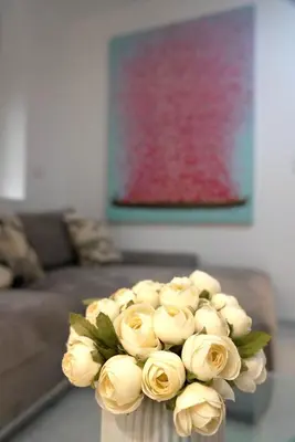 a vase filled with white roses in a living room at Heart of Belgrade in Belgrade