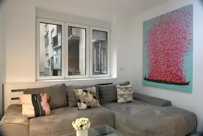 a living room with a couch and two windows at Heart of Belgrade in Belgrade