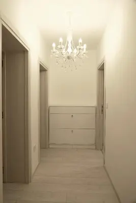 a hallway with a chandelier in a white room at Heart of Belgrade in Belgrade
