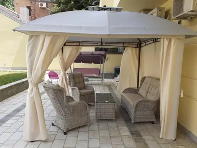 a gazebo with chairs and a table under it at Ninis city flat in Belgrade