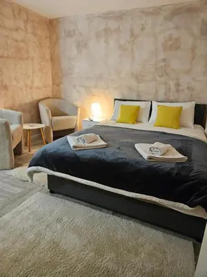 a bedroom with a large bed with towels on it at Apartman Helena 2 in Lazarevac